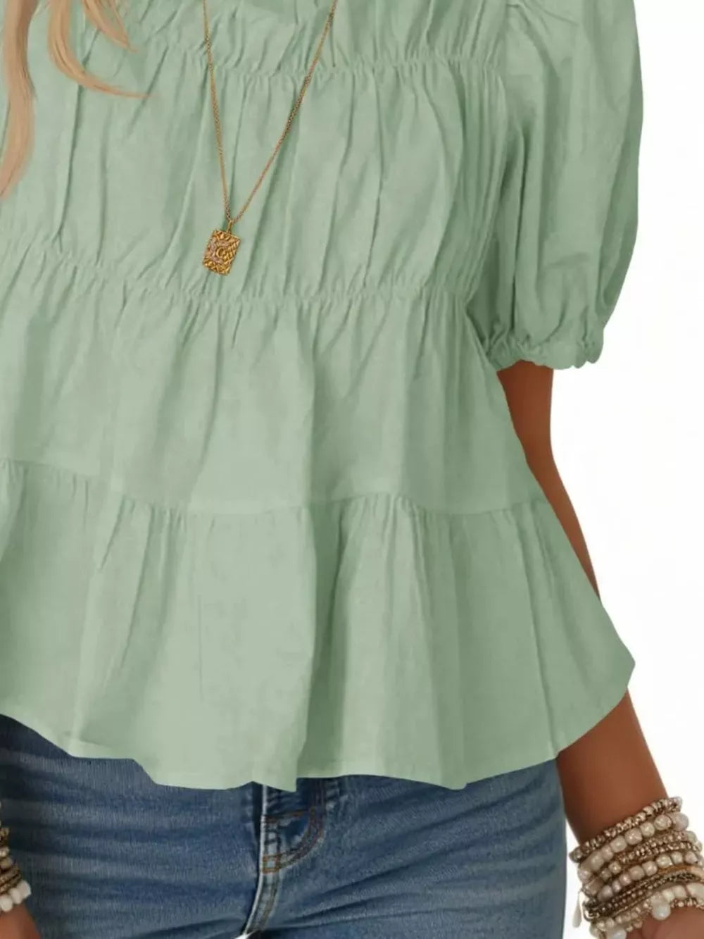 Light green maternity blouse with puff sleeves, smocked bodice, and tiered ruffles.