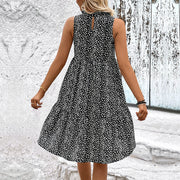 Black ditsy print mini dress with tiered skirt and mock neck.