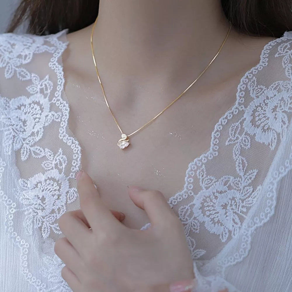 Gold swan pendant necklace with zircon detail on a delicate chain.