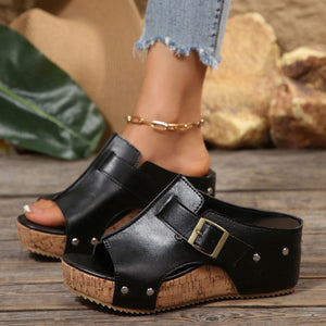 Black open-toe wedge sandals with buckle detail and cork platform.