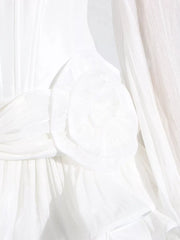 White ruffle mini dress with balloon sleeves, featuring a ruched bodice and delicate fabric detail.