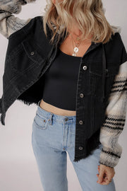 Black denim trucker jacket with plaid sleeves and hood, frayed hem