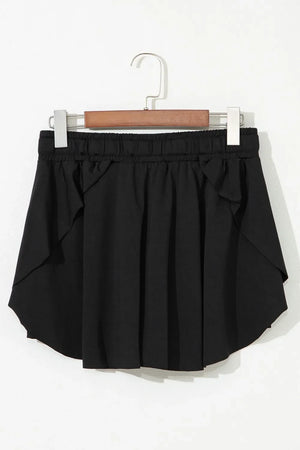 Black flared skort with tie waist and ruffled hem detail.