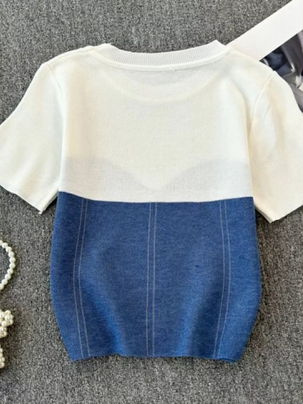 Color block knit t-shirt in white with blue, featuring ribbed detail and vertical stitching.