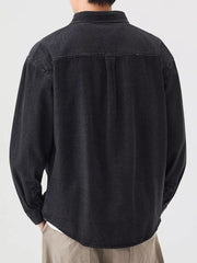 Men's black denim overshirt with button-up front and chest pocket detail.