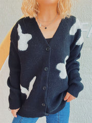 Black acrylic cardigan with white floral appliqué, V-neck, button front, and long sleeves.