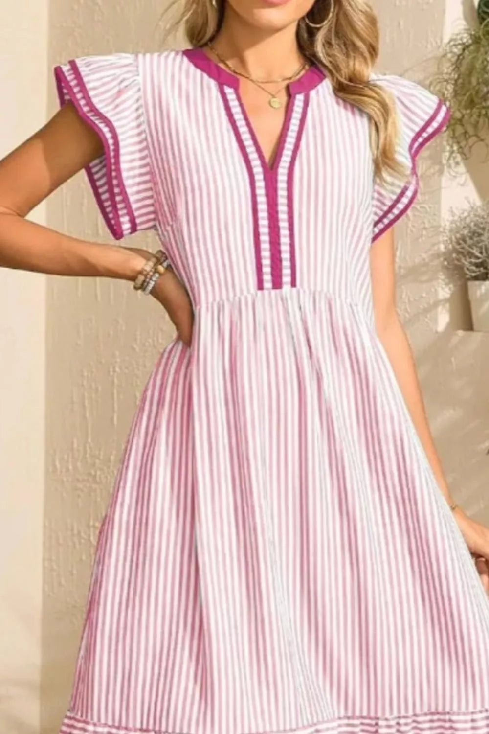 Blush pink striped midi dress with ruffle sleeves and V-neck with contrast trim.