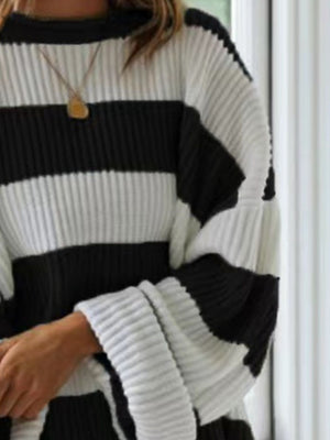 Black and white striped oversized knit sweater with ribbed texture and wide sleeves.