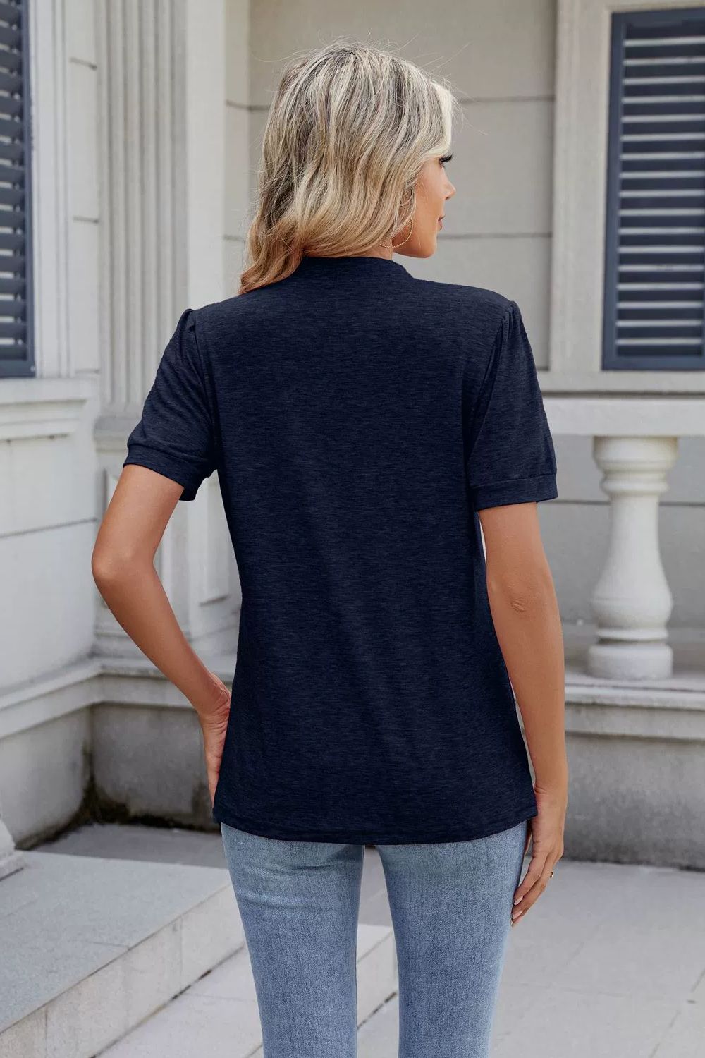 Dark navy short sleeve t-shirt with pleated yoke detail and mock neck.