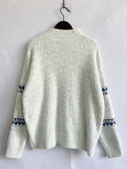 Geometric knit mockneck pullover in Eggshell with blue diamond pattern on sleeves.