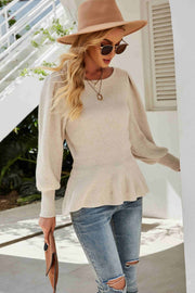 Cream ribbed knit peplum top with puff sleeves and a round neckline.