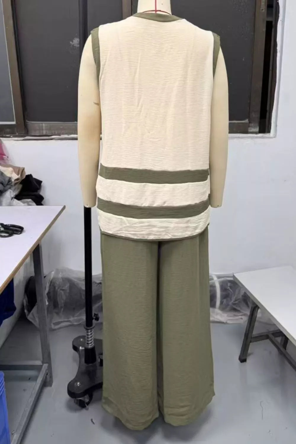 Moss green flowy pants and a cream sleeveless top with horizontal stripes.
