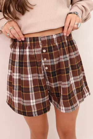 Brown plaid cotton shorts with elastic waist and button details.