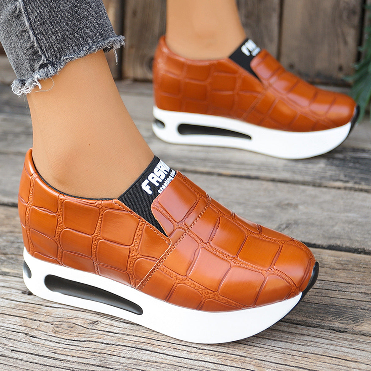 Brown crocodile pattern platform slip-on flats with chunky white soles.