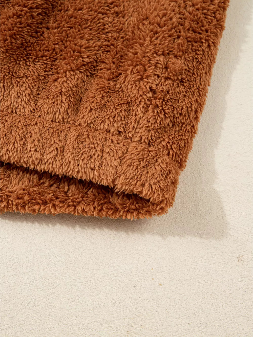 Cozy brown fuzzy vest detail, soft plush texture.