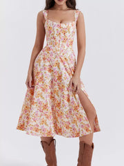 Floral midi dress with side slit and sweetheart neckline in cream with pink and orange flowers.