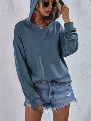 Dusty Blue boxy hooded sweatshirt with split V-neck and cuffed sleeves.