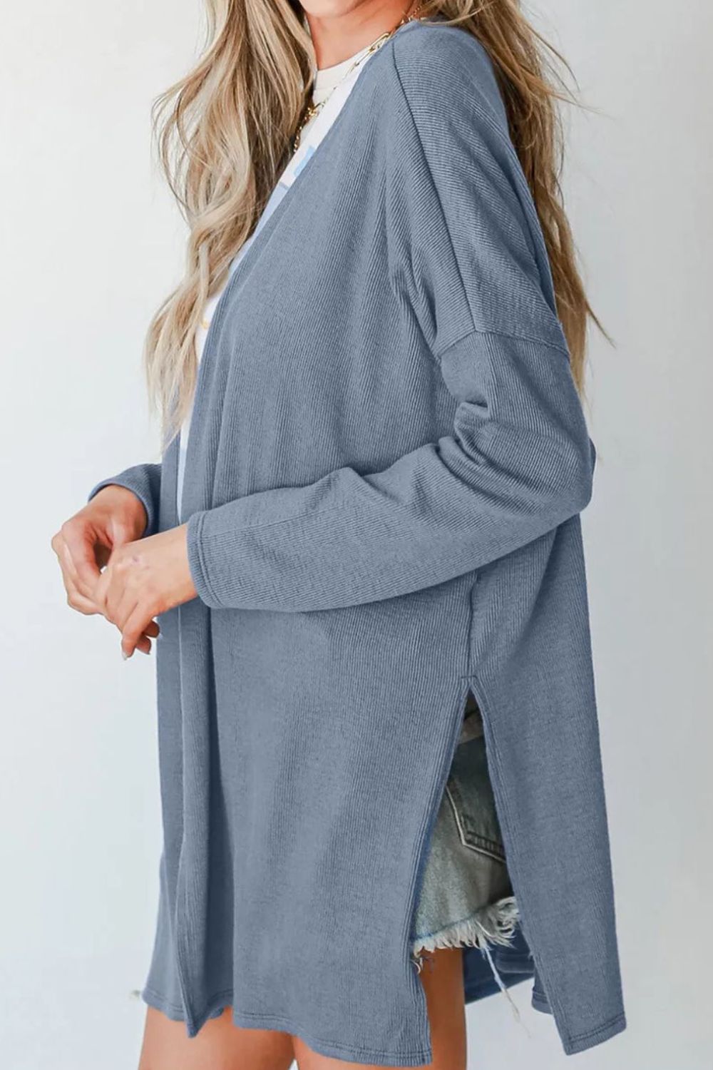 Dusty blue ribbed knit cardigan with side slits and long sleeves.