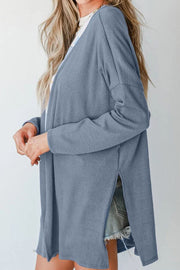 Dusty blue ribbed knit cardigan with side slits and long sleeves.