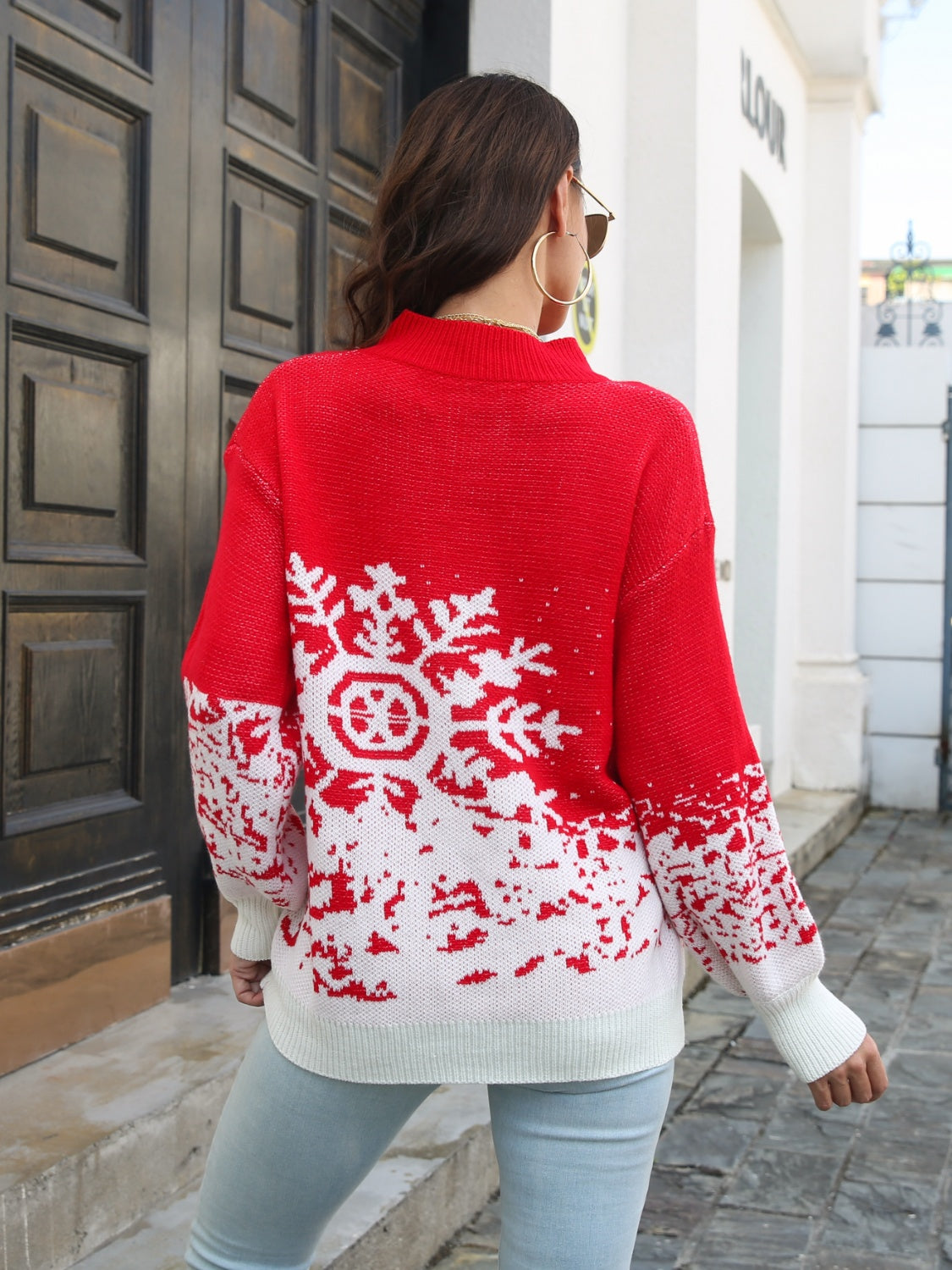 Red acrylic mock neck sweater with white snowflake intarsia pattern and ribbed cuffs.