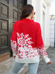 Red acrylic mock neck sweater with white snowflake intarsia pattern and ribbed cuffs.