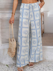 Geometric print wide-leg trousers in light blue with drawstring waist and pockets.