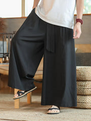 Men's black wide-leg sweatpants with drawstring and tie detail.