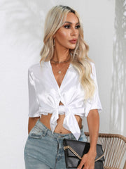 White satin tie-front collared shirt with button detail and short sleeves.
