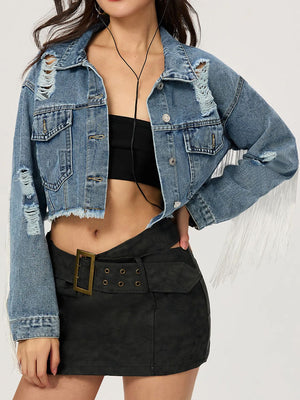 Distressed denim trucker jacket in medium wash with fringe trim and frayed hem.