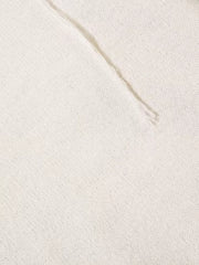 Cream knit sweater detail with textured stitching and abstract pattern.