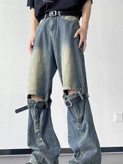 Distressed blue wide-leg jeans with decorative straps and knee cutouts.