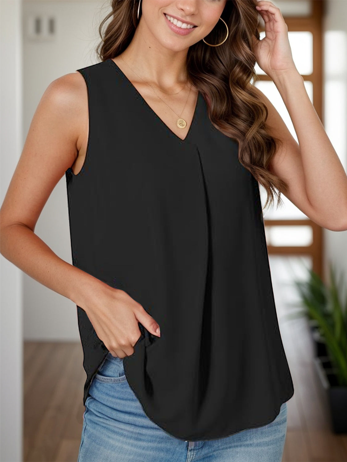 Black sleeveless V-neck blouse with front pleats and a relaxed fit.