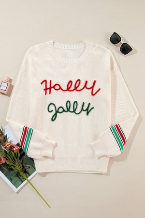 Ivory knit sweater with red "Holly" and green "Jolly" embroidery, striped cuffs.