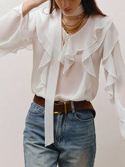 White chiffon blouse with V-neck, ruffle trim, and tie detail.