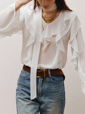 White chiffon blouse with V-neck, ruffle trim, and tie detail.