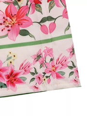 Charming floral midi dress with pink lilies and green accents.