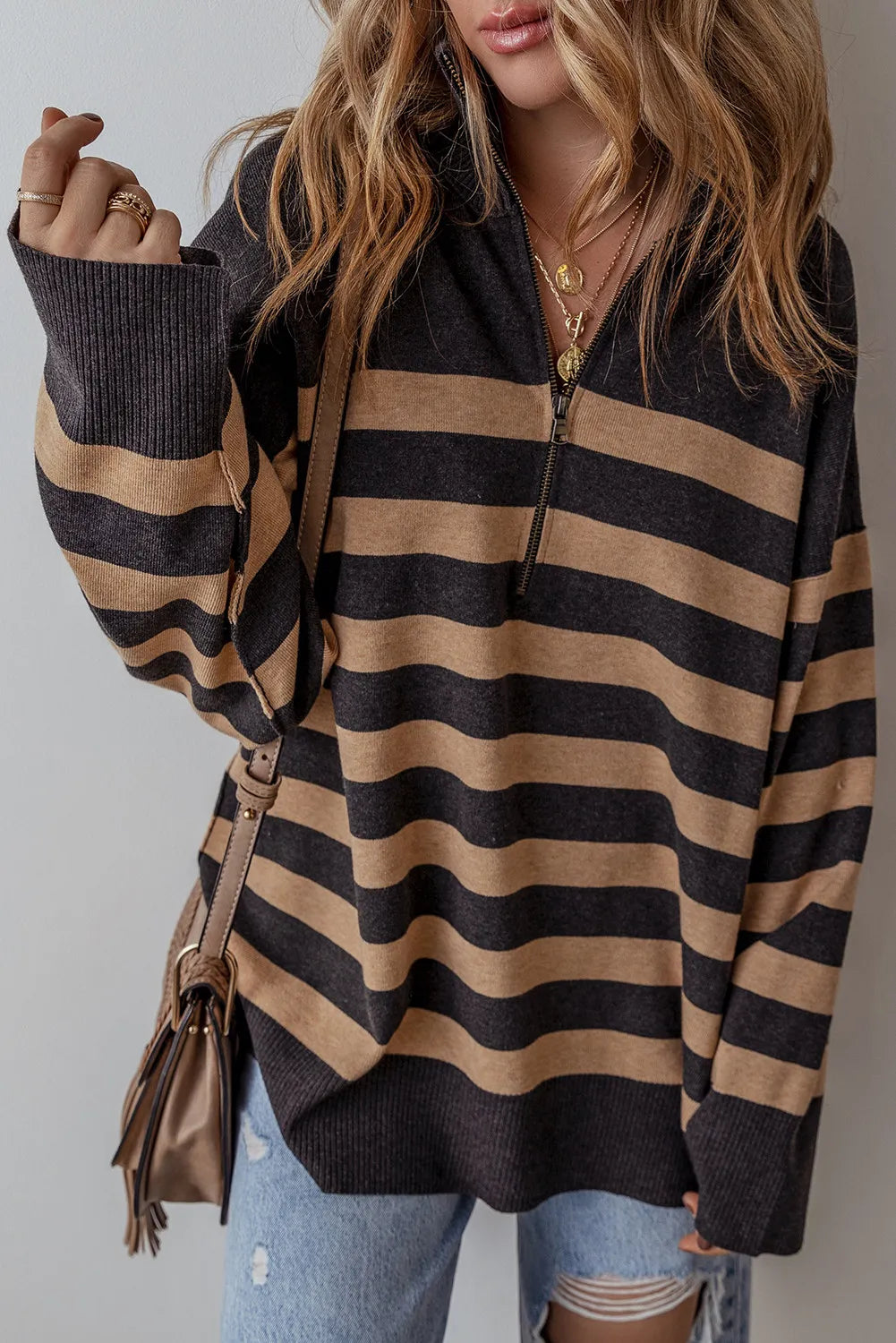 Oversized black and tan stripe knit pullover with half-zip neckline and ribbed cuffs.