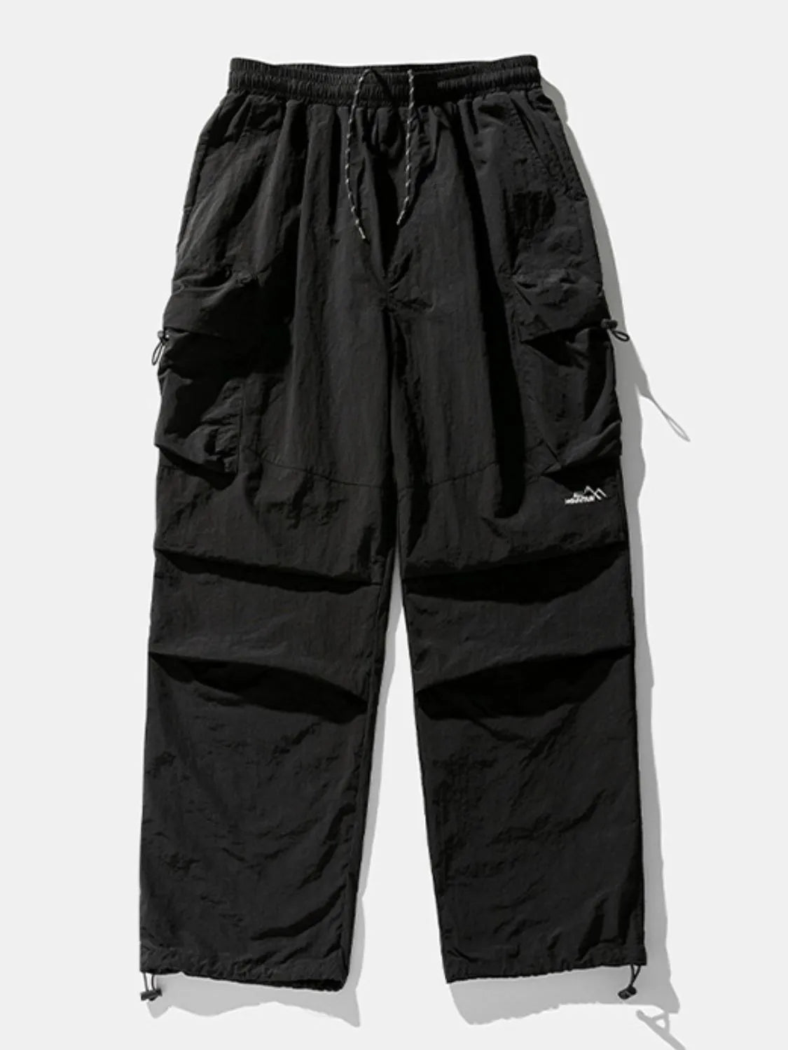Black oversized utility cargo pants with drawstring waist and multiple cargo pockets.
