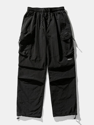 Black oversized utility cargo pants with drawstring waist and multiple cargo pockets.
