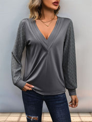 Dark gray blouse with lace inset sleeves and a deep V-neckline.