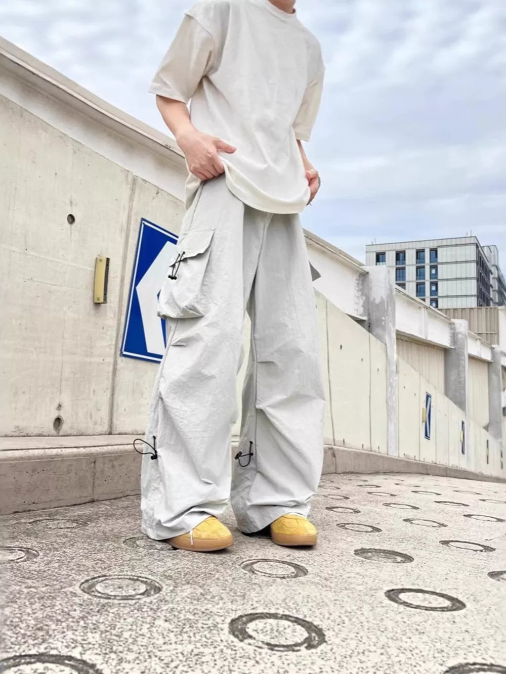 Grey cargo sweatpants with adjustable drawstring ankles and multiple pockets.