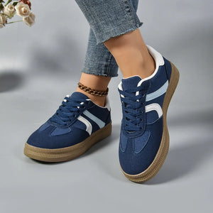 Navy suede platform sneakers with curved white and light blue stripes and a gum sole.
