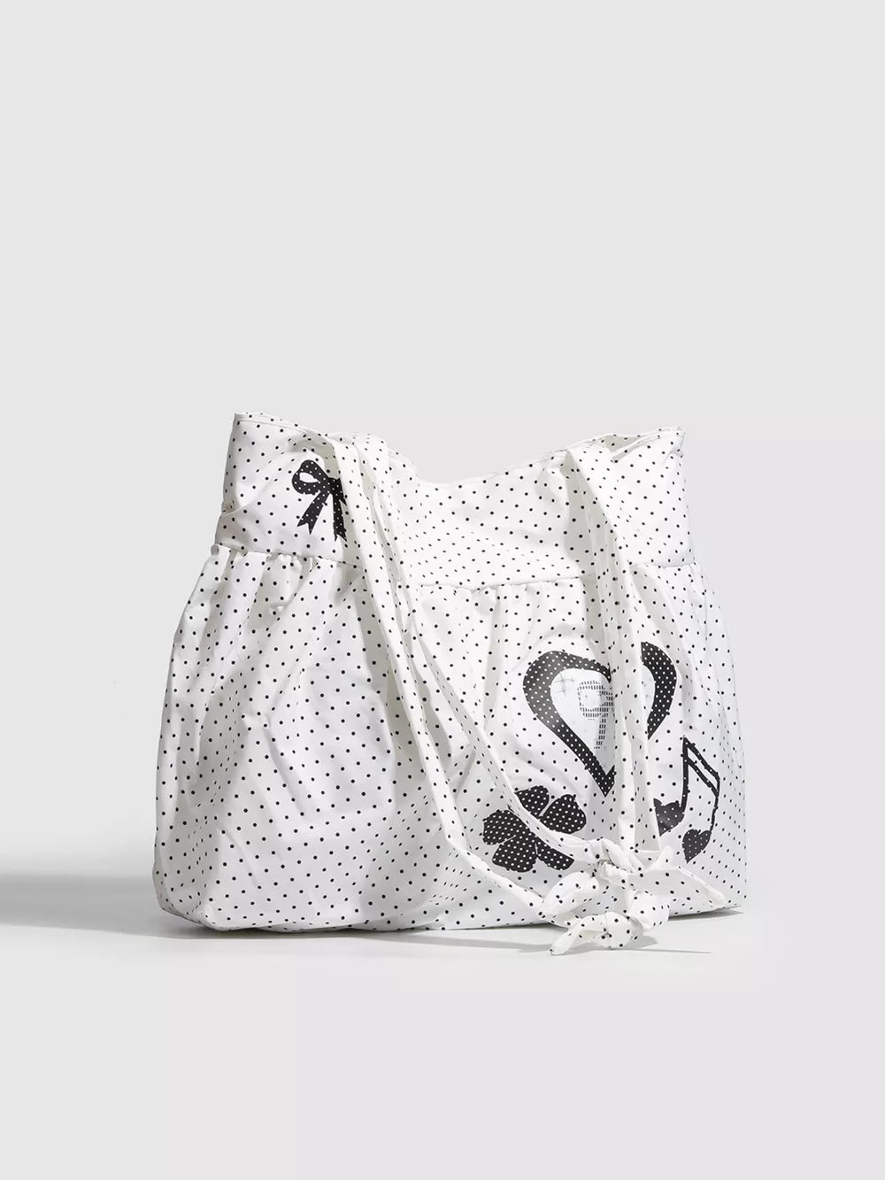 White canvas shoulder bag with black polka dots, heart appliqué, bow and music note.