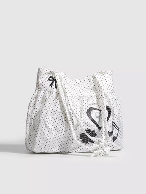 White canvas shoulder bag with black polka dots, heart appliqué, bow and music note.