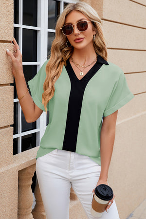 Light green blouson top with black contrast V-neck and short sleeves.