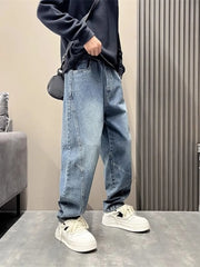 Oversized blue washed men's jeans with tapered cuffs and unique paneling detail.