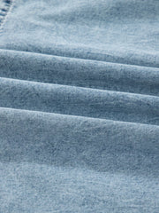 Tiered denim overall dress in light blue cotton with a textured weave.