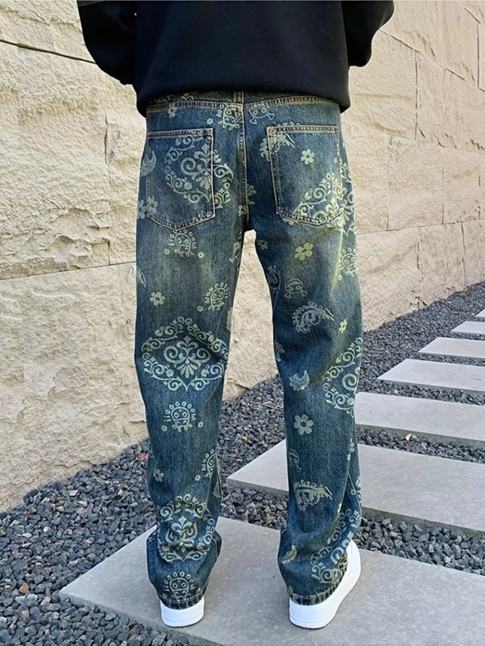 Men's blue denim jeans with heritage floral print and distressed wash.
