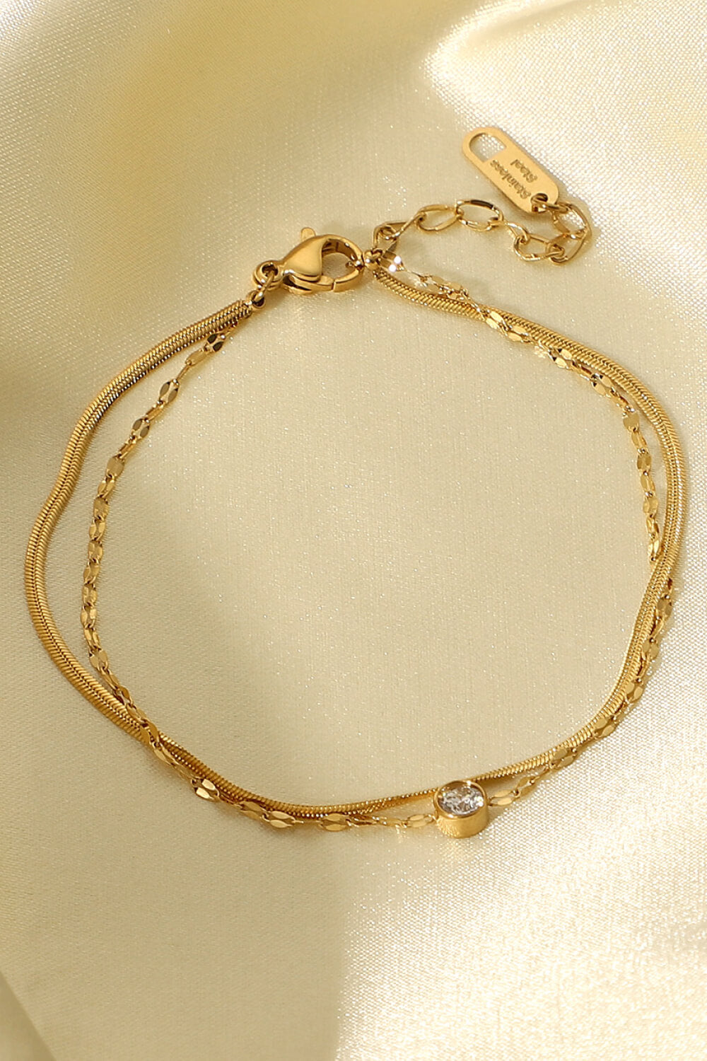 Gold double-strand bracelet with pavé charm and snake chain detail