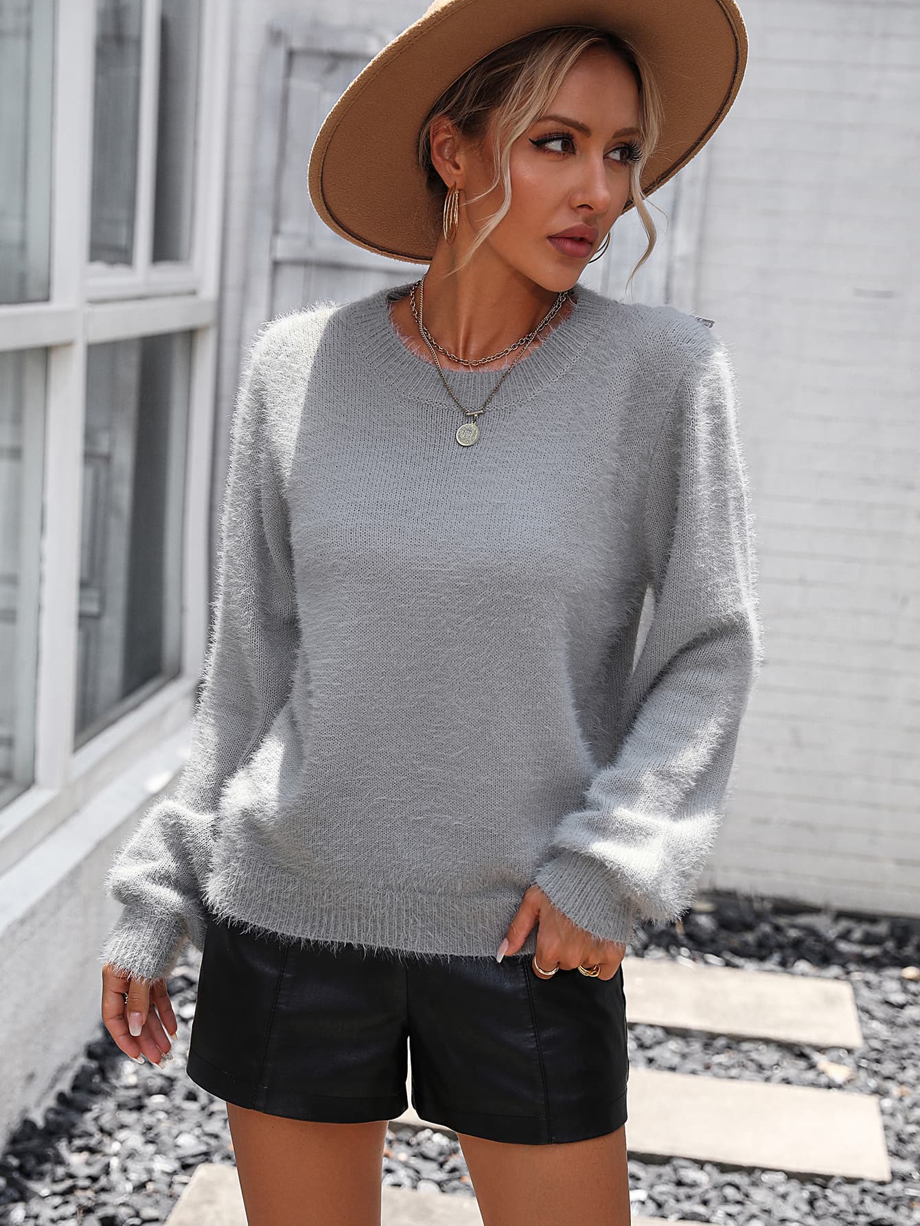 Light gray fluffy knit sweater with crew neck and long sleeves, styled with black shorts.